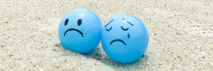 Na pešcanoj plazi leze dve tuzne plave lopte