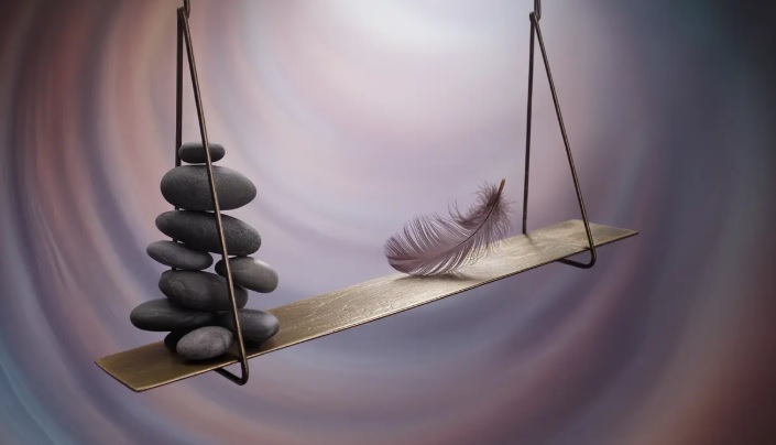 Na mntalnoj ploci koju drze metalni trouglovi stoji gomila naslaganih kamencica i pticije pero